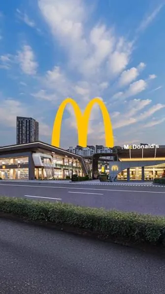 Developer’s render of the McDonald’s unit at Solitaire Walk with tall golden arches above the roof and a high-rise behind
